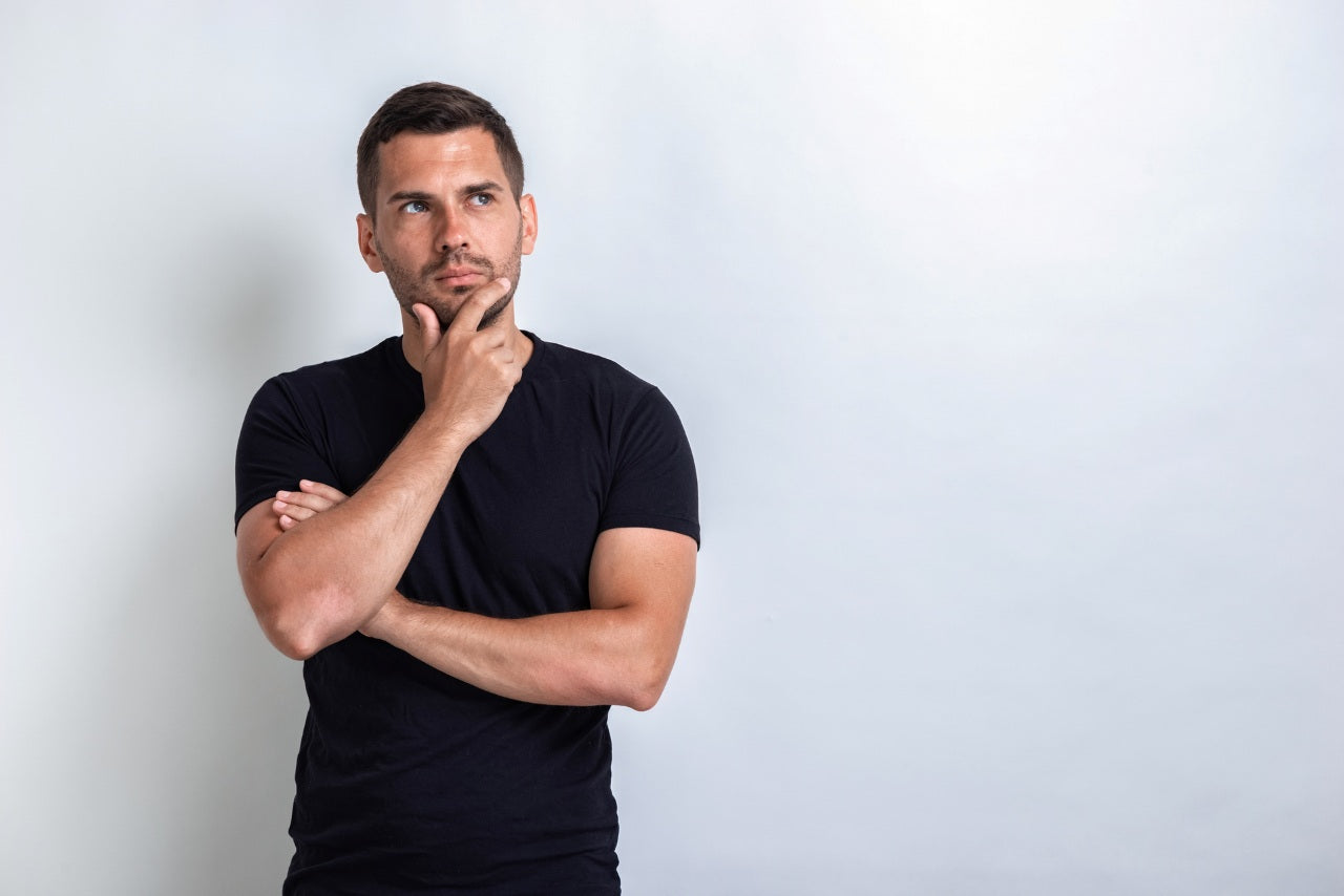Man wearing a fitted black compression shirt against a clean studio background, men’s compression shirt