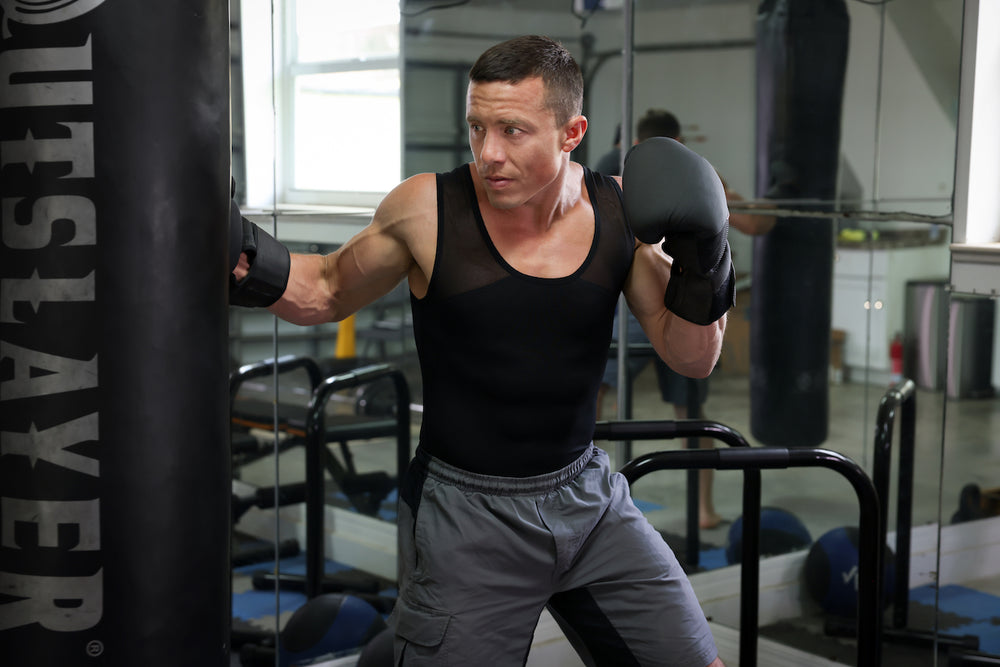 Man wearing a black compression tank while boxing